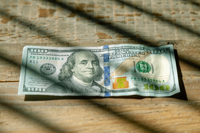 100 Dollar Bill Sitting On a Table